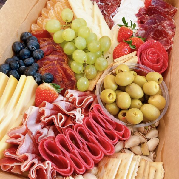 Imagen de la Tabla Mediana de Picoteo. Se ven embutidos, quesos, frutas y encurtidos.